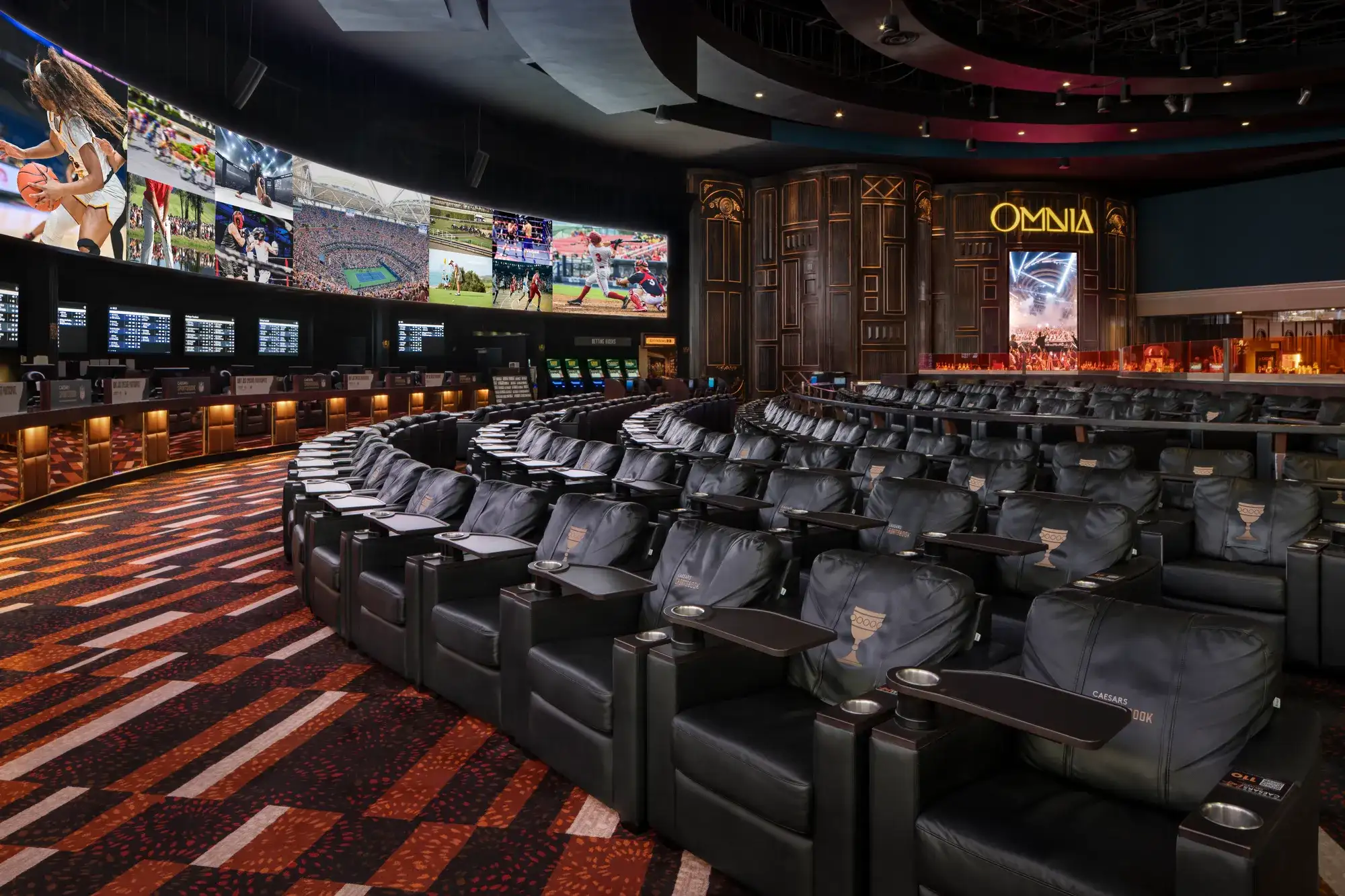 Caesars Palace Sportsbook interior with 143-foot HD video wall and lush leather chairs for watching every game.
