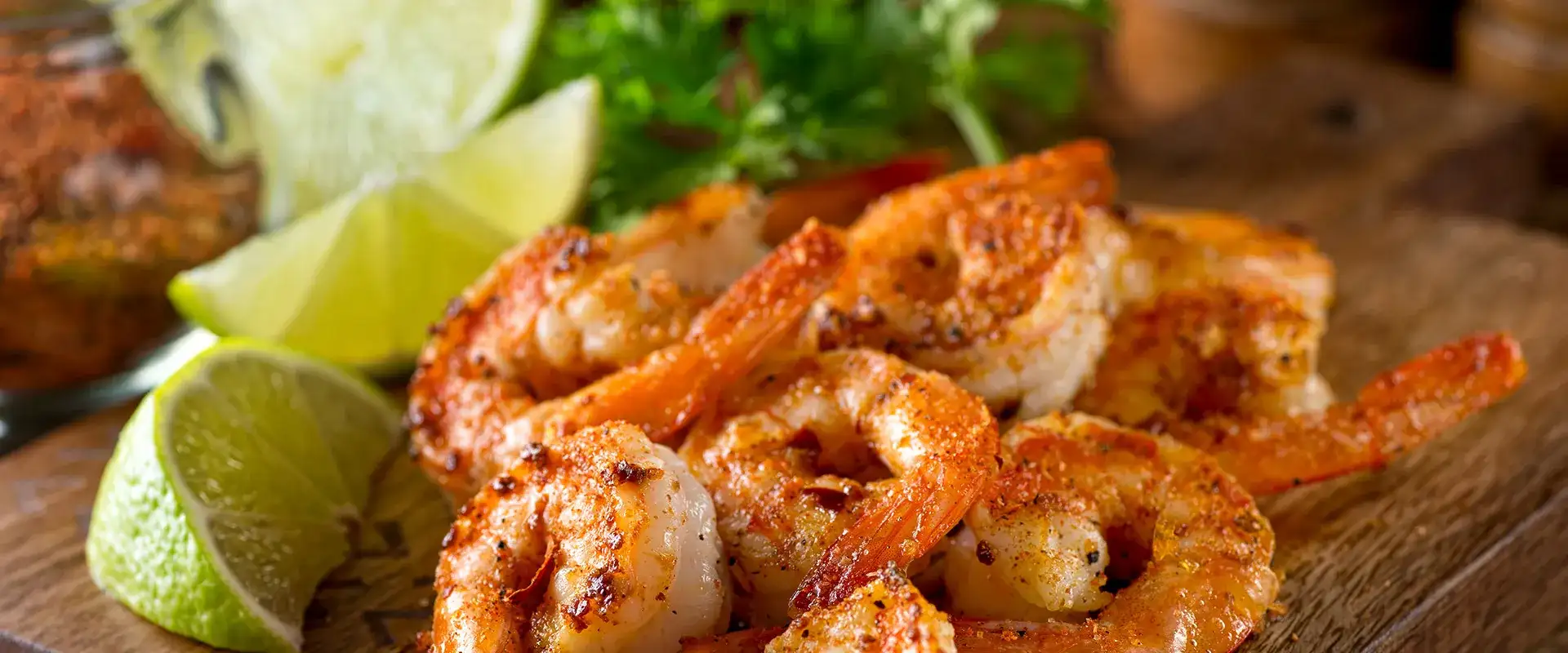Seasoned shrimp with lime wedges.