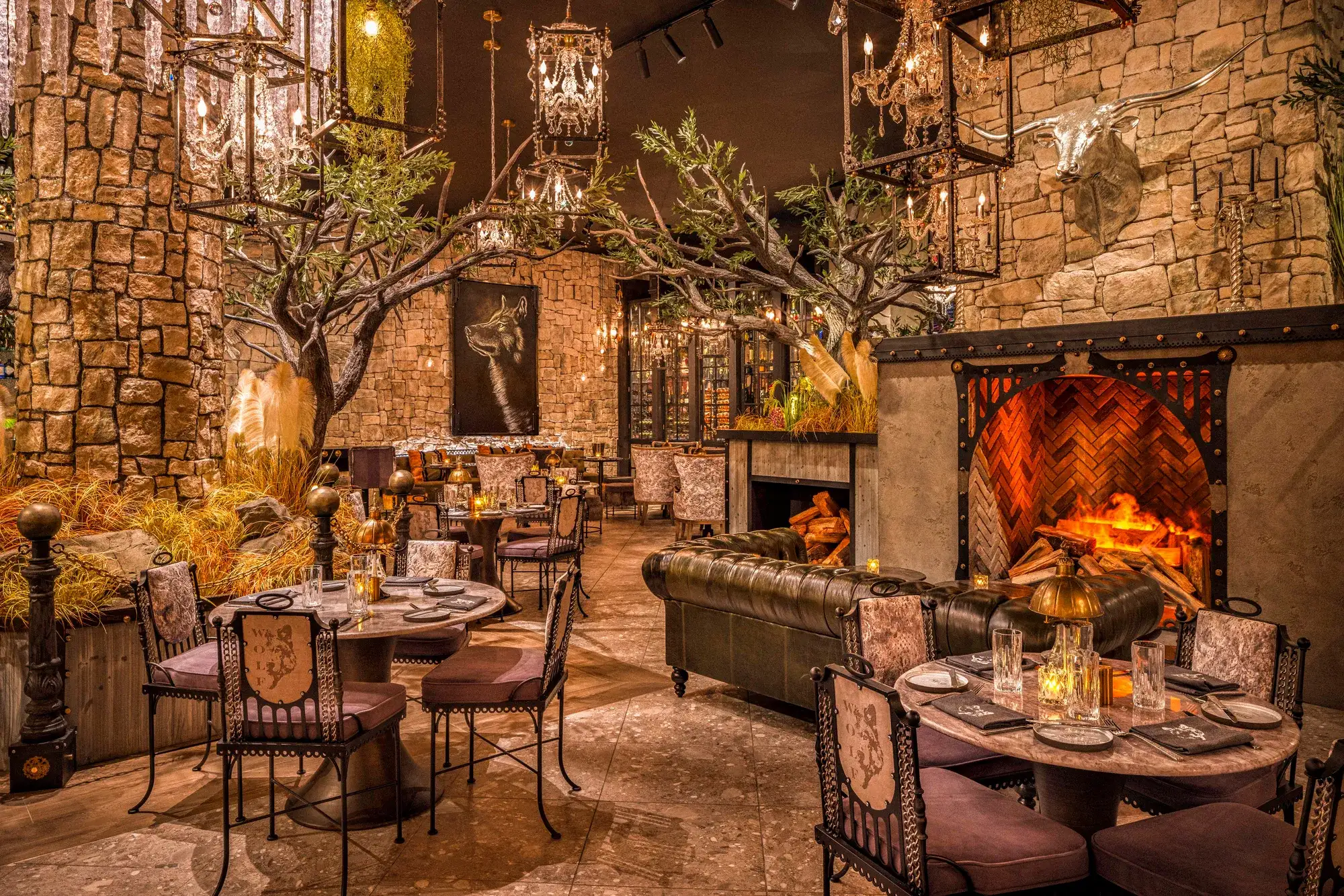 Wolf by Vanderpump at Caesars Republic Lake Tahoe with fireplace, stone walls, chandeliers and candlelit tables