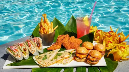 Food sampler with tacos, quesadilla, burgers, fries and drink.