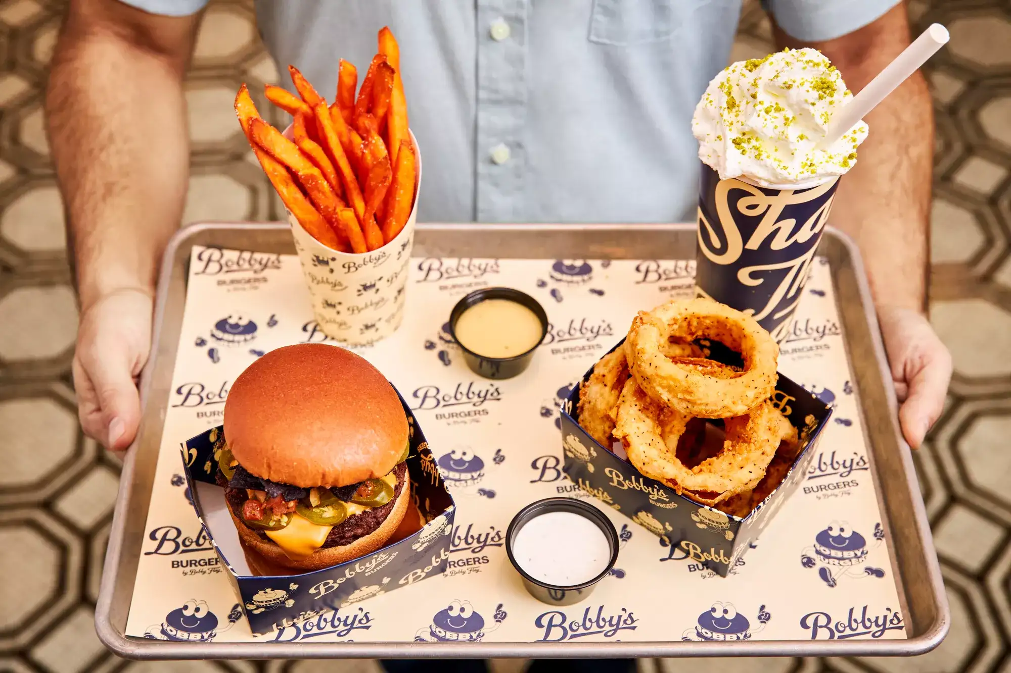Food Tray from Bobby's Burgers, including fries, onion rings, a shake and a cheeseburger.
