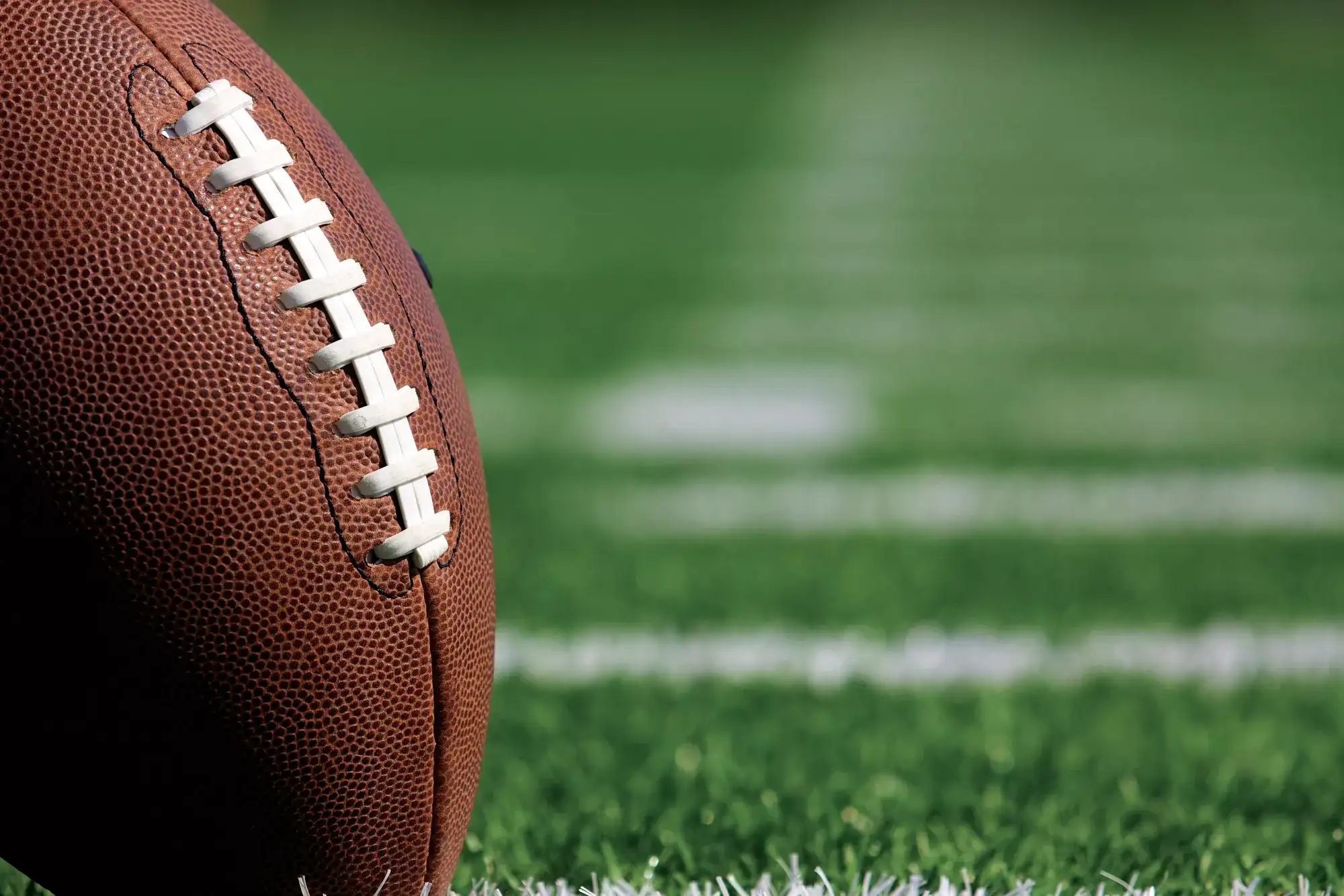 Close-up of an American football on a grass football field