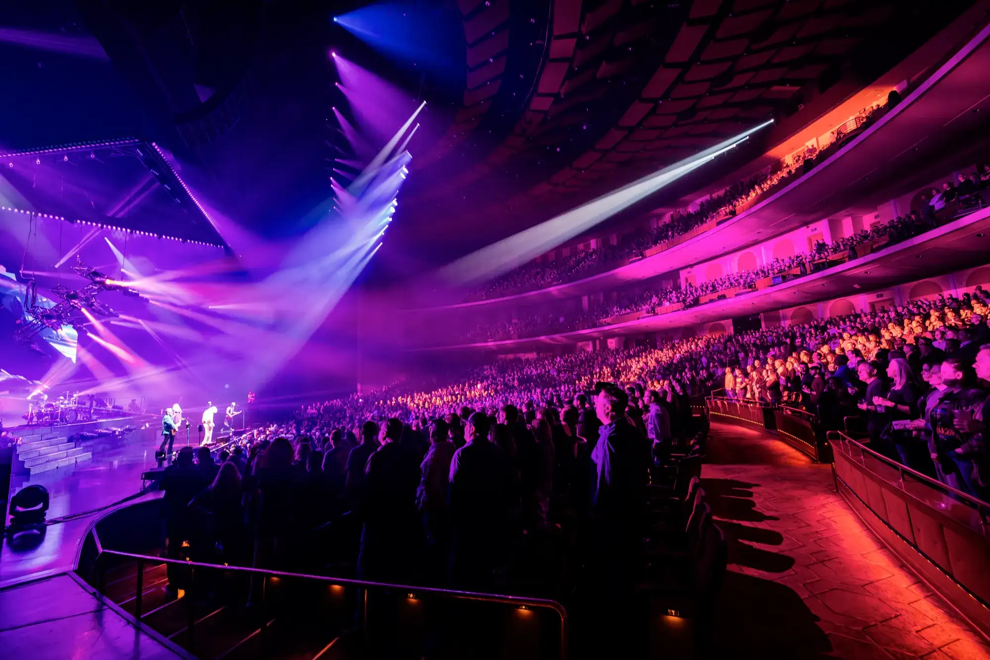 Concert crowd watching a live performance under purple stage lights at The Colosseum at Caesars Palace