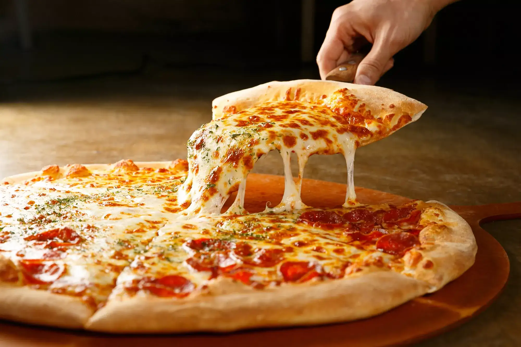 Raising a slice of pizza from a full pizza