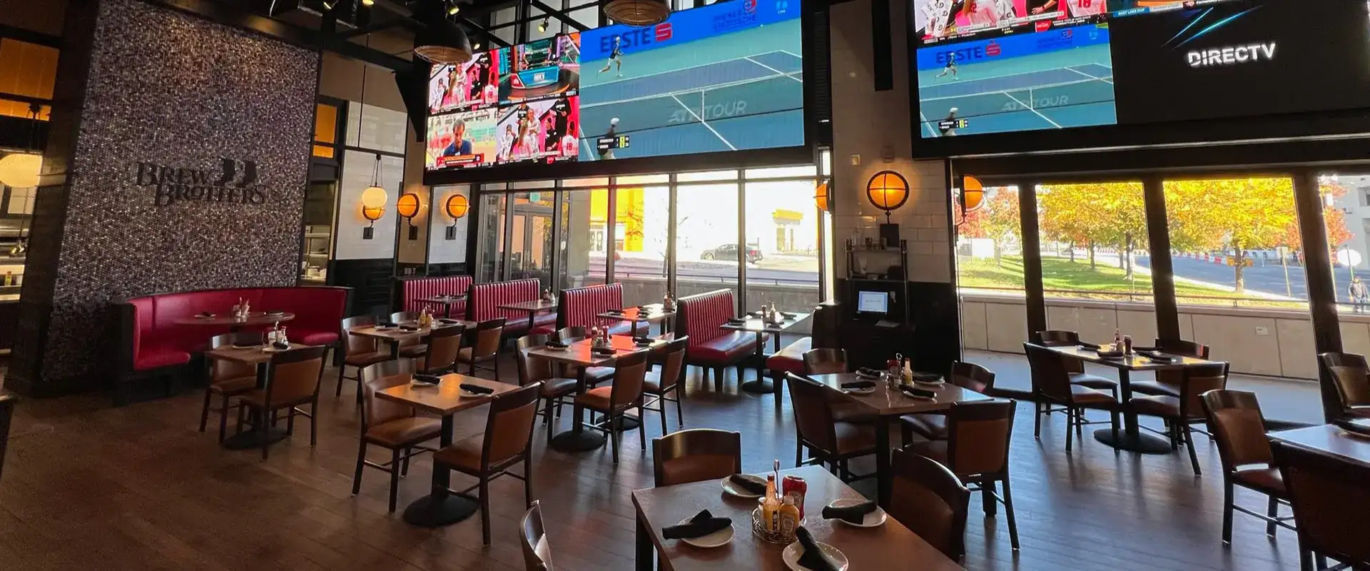 Brew Brothers seating area with floor to ceiling windows and multiple TVs.