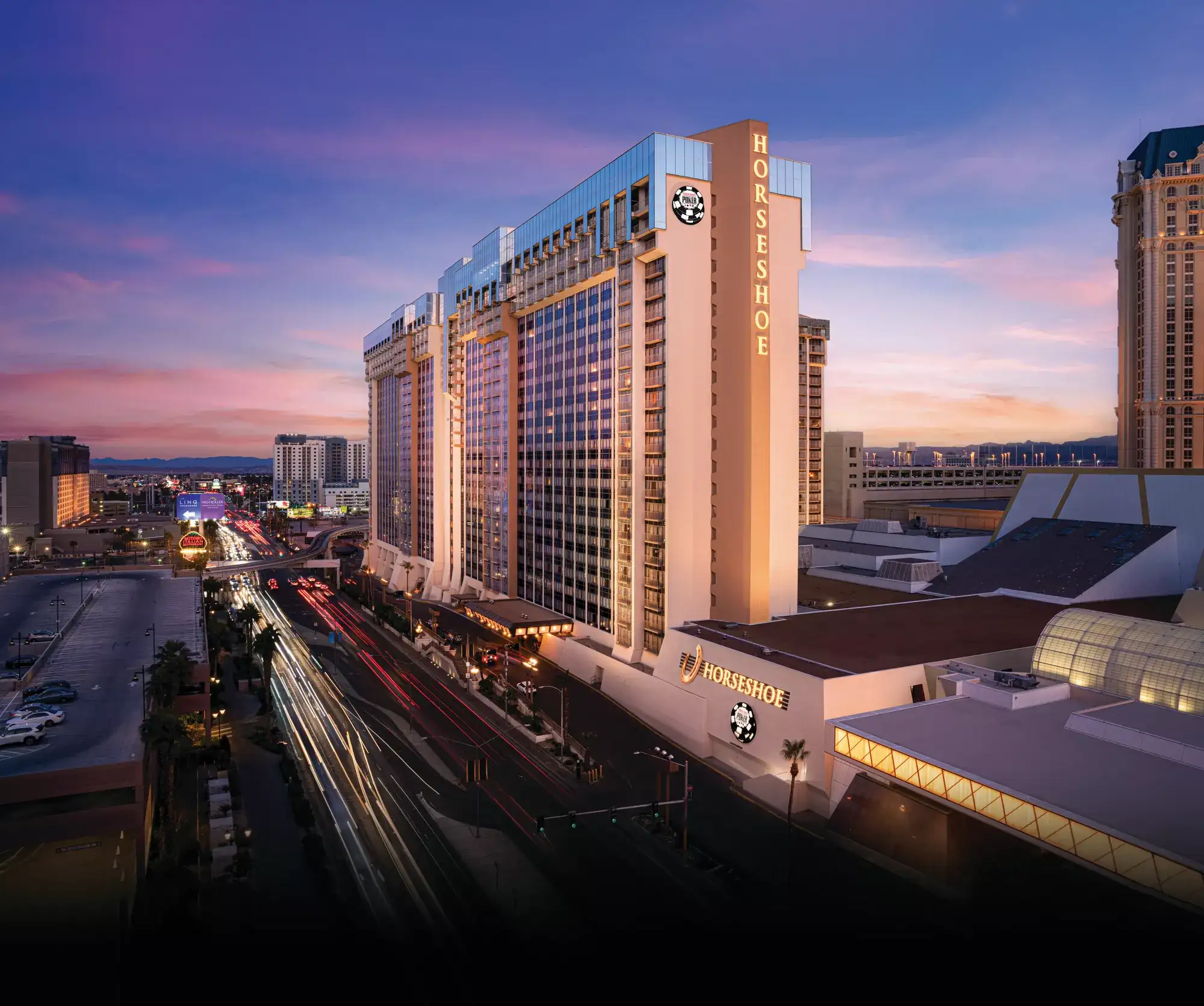Evening exterior of Horseshoe Las Vegas on the Strip, glowing marquee and lights for a budget-friendly stay.