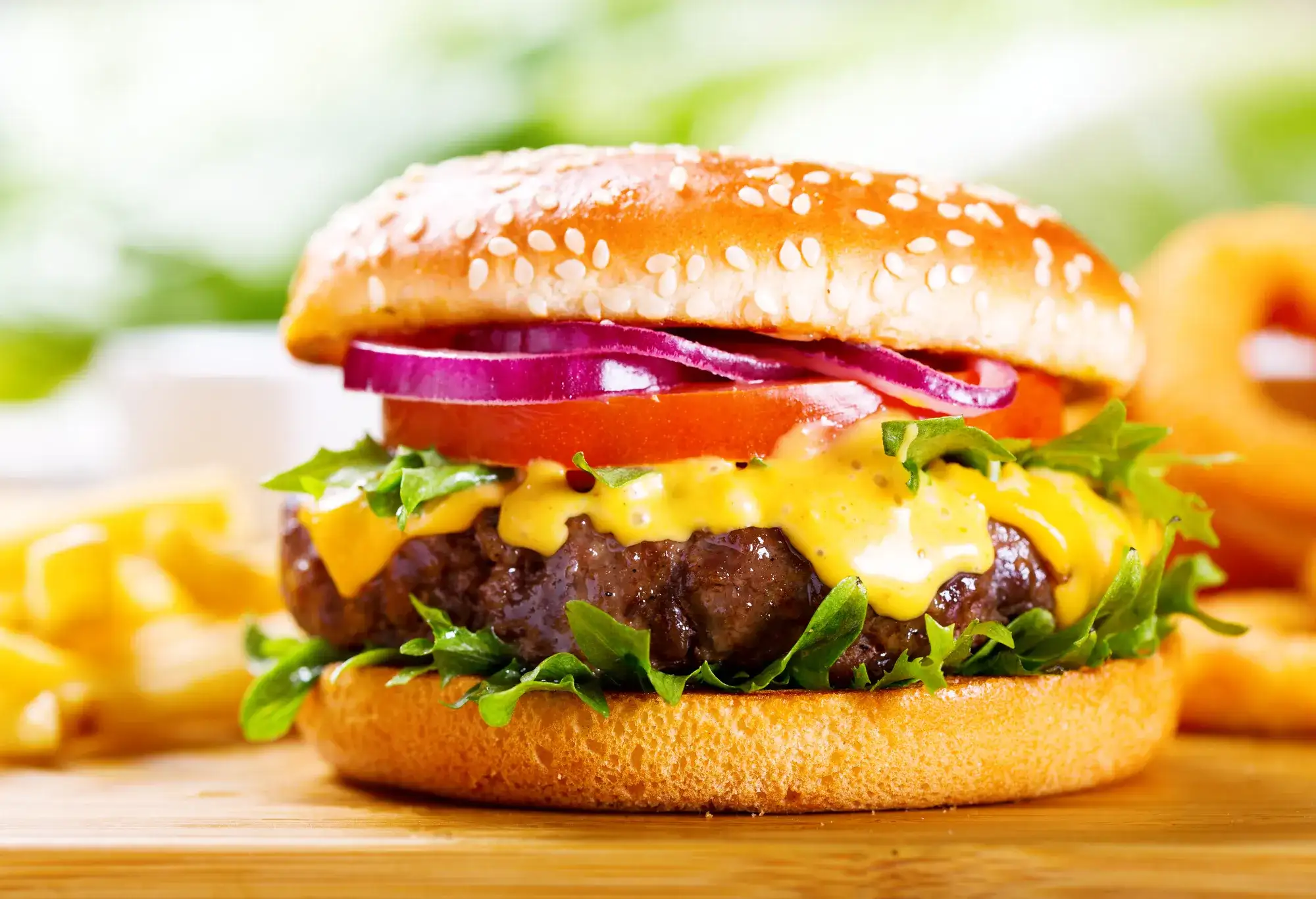 Cheeseburger with lettuce, tomato and onion.