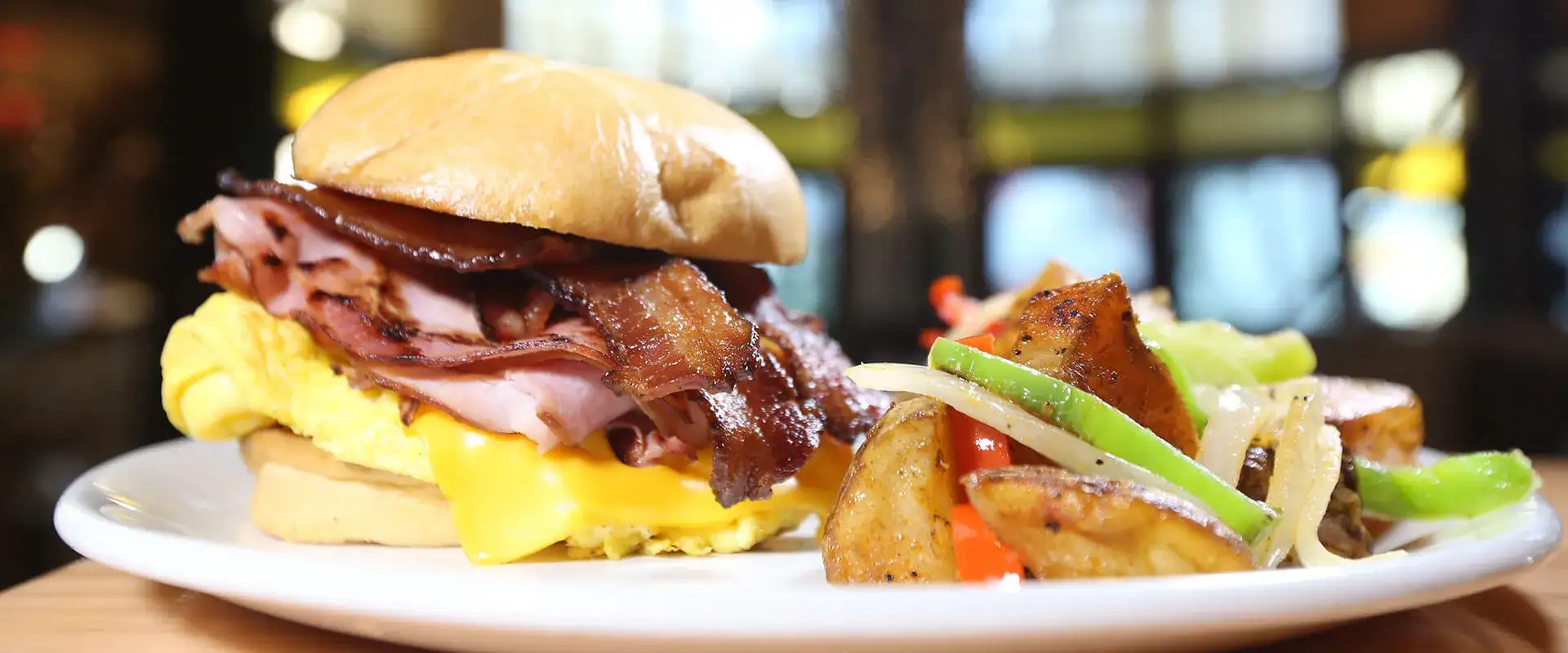 Breakfast sandwich with side of potatoes.