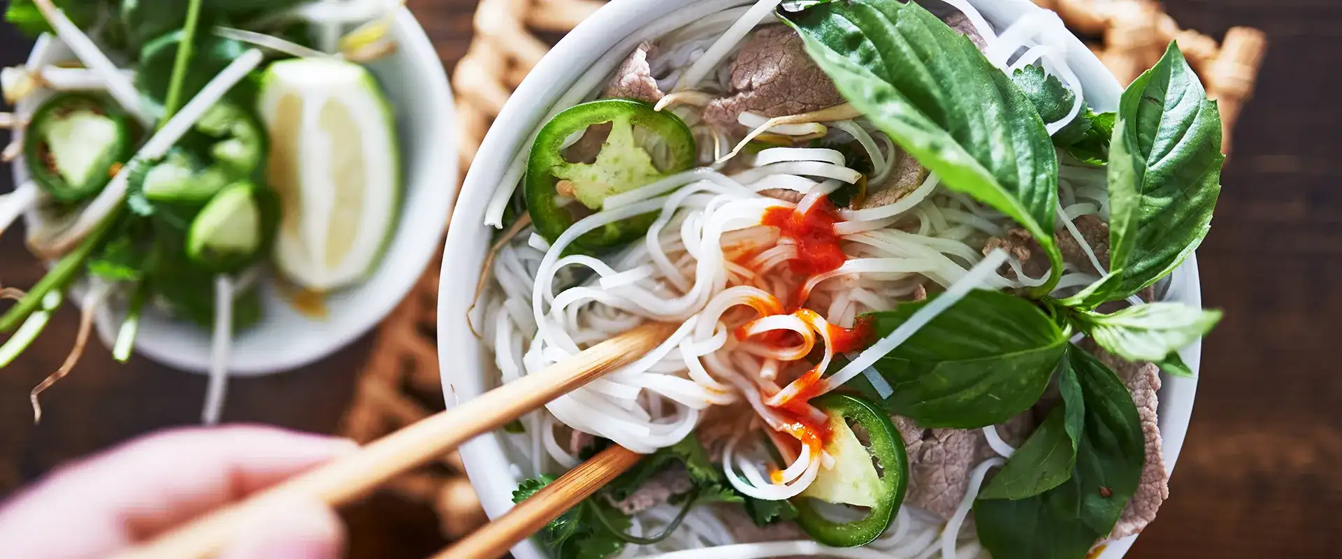 Bowl of noodles with fresh basil and jalapeno.