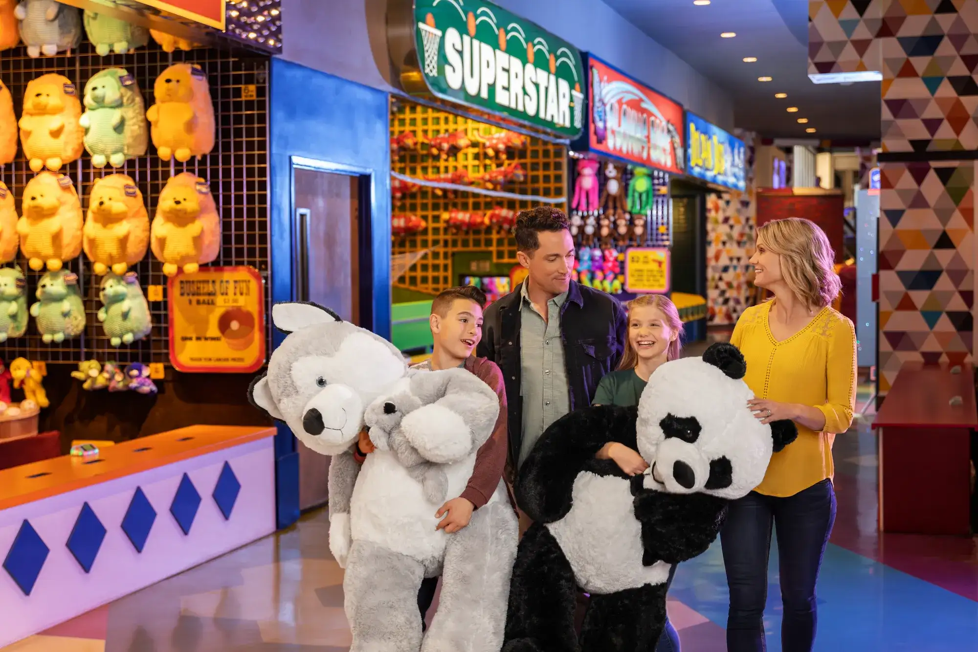 Family with kids holding stuffed prizes won at Carnival Midway inside Circus Circus Reno, a downtown family resort