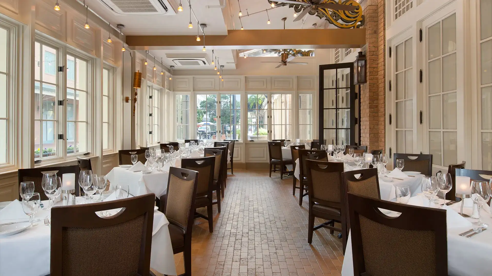 Ruth's Chris New Orleans tables set with white tablecloths, wine glasses, and cutlery.