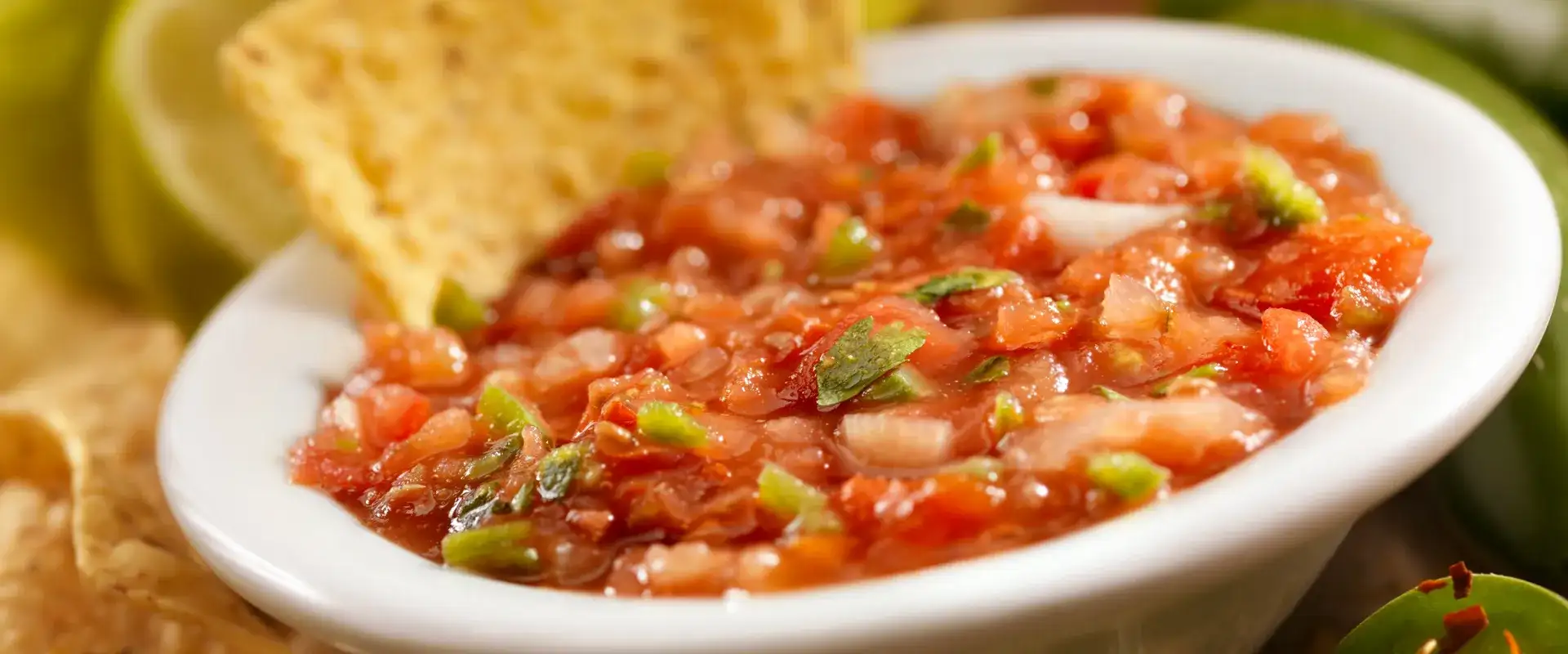 Bowl of chili with a corn chip in it.