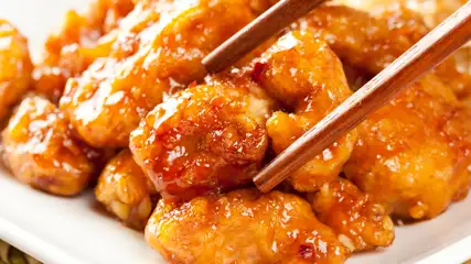 Orange chicken with chopsticks.