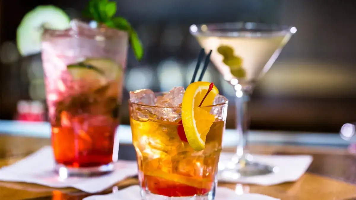 Three different alcoholic beverages sitting on the bar