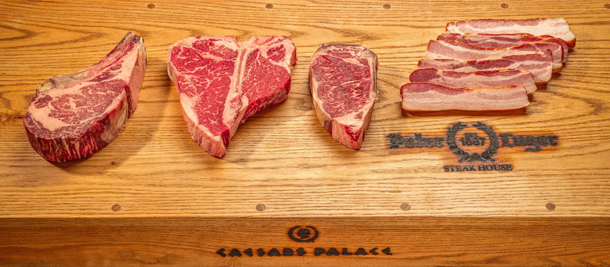 Raw steaks on a Peter Luger cutting board