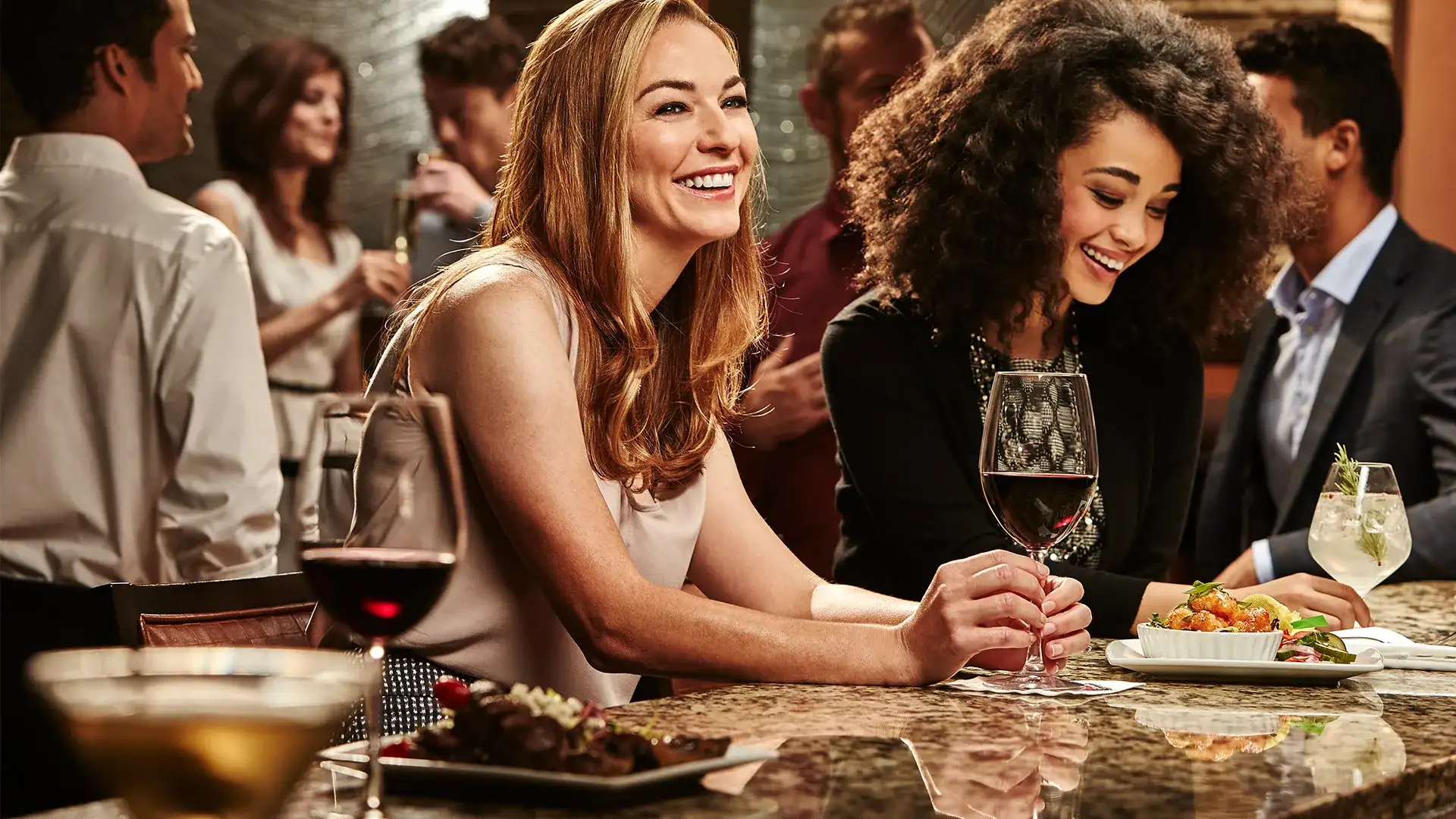 People enjoying drinks and food in a lounge area.