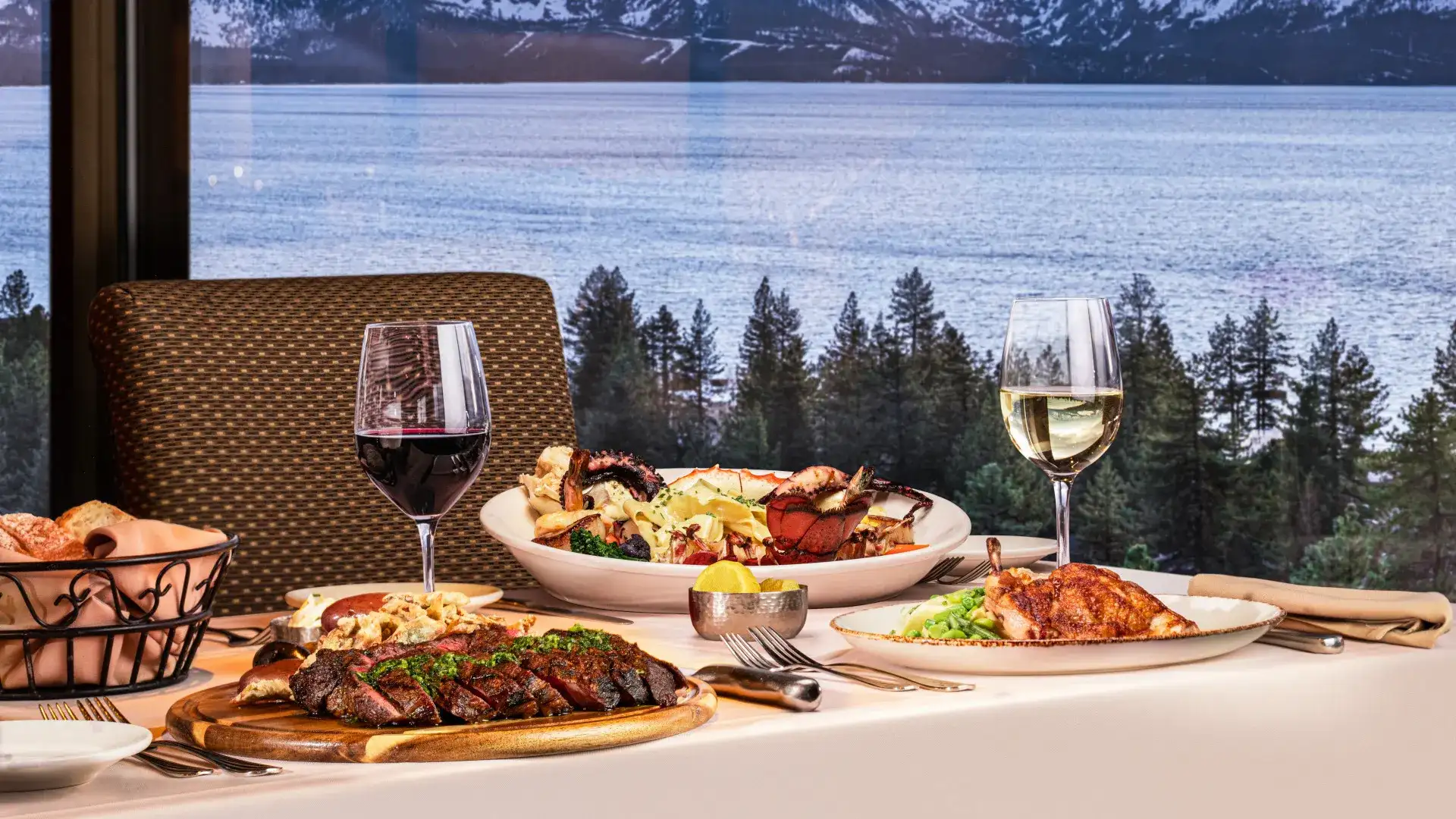 Different Food served with wine on table overlooking Lake Tahoe