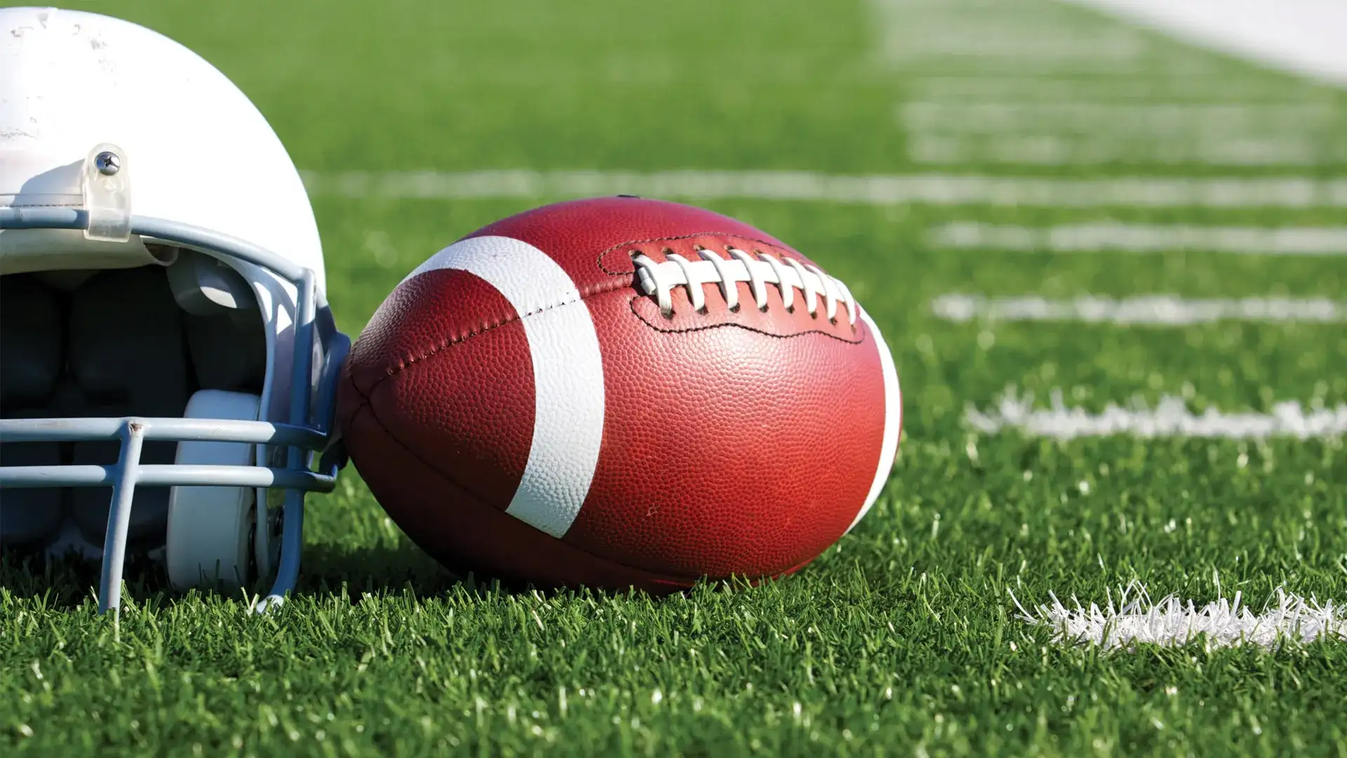 Helemet and football sitting on turf