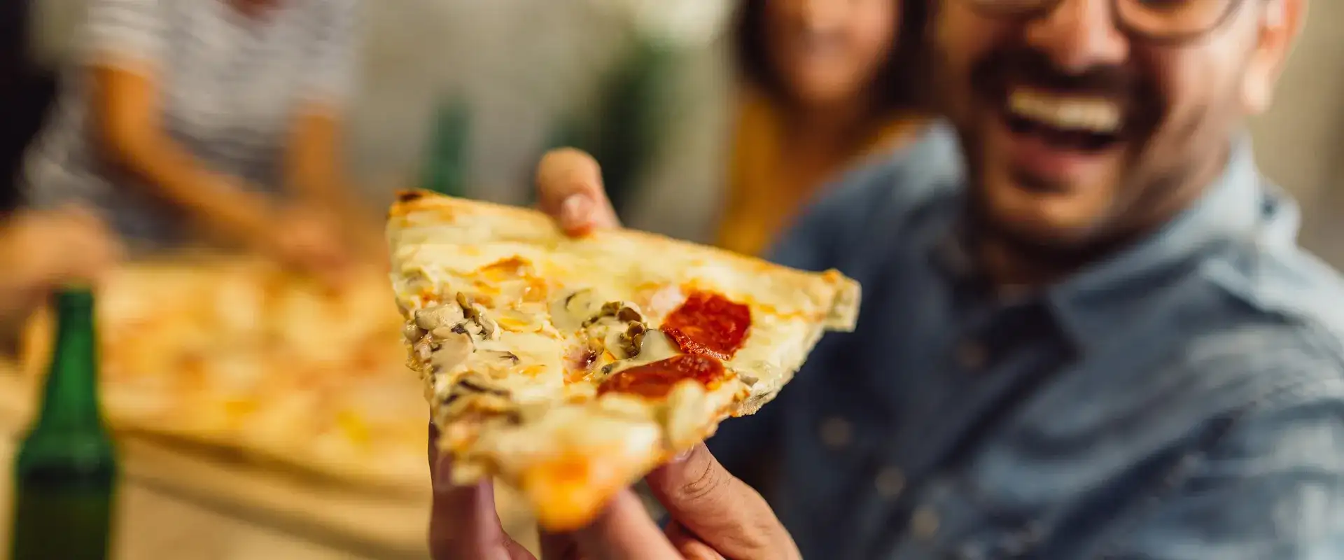 Man holding a slice of pizza.