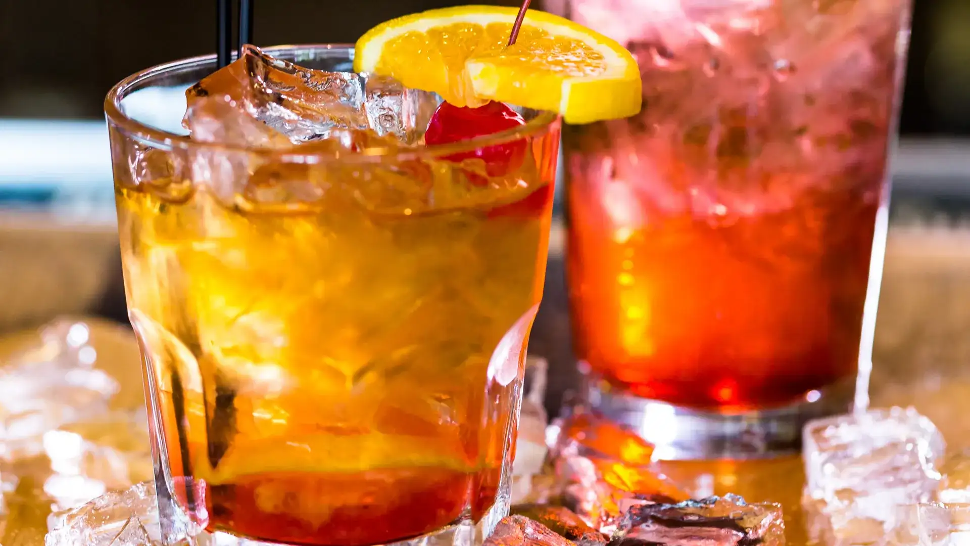 Fruity cocktails garnished with orange slices, cherry, and cucumber.