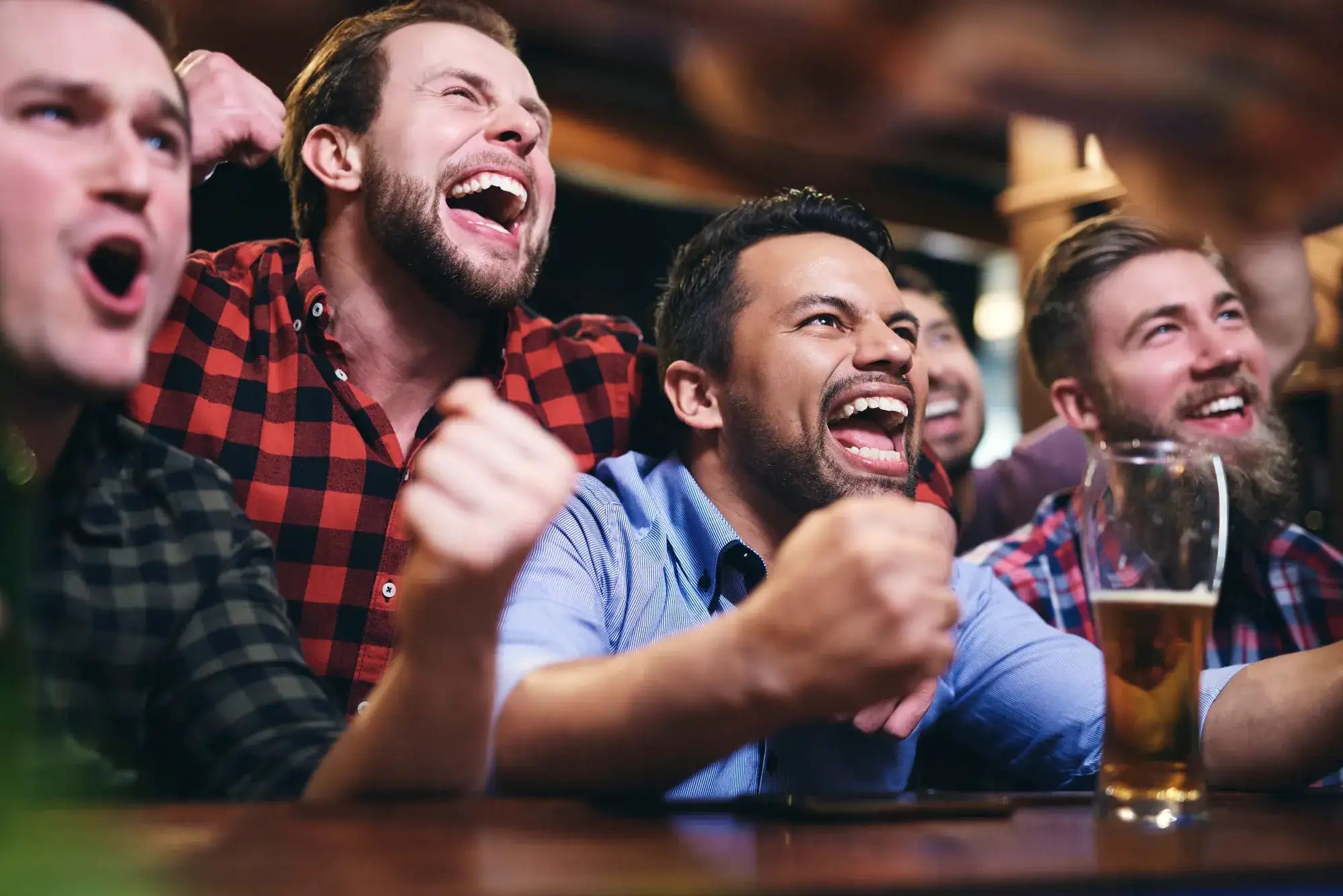 Group of adult men gathered around drinks during a bachelor weekend outing