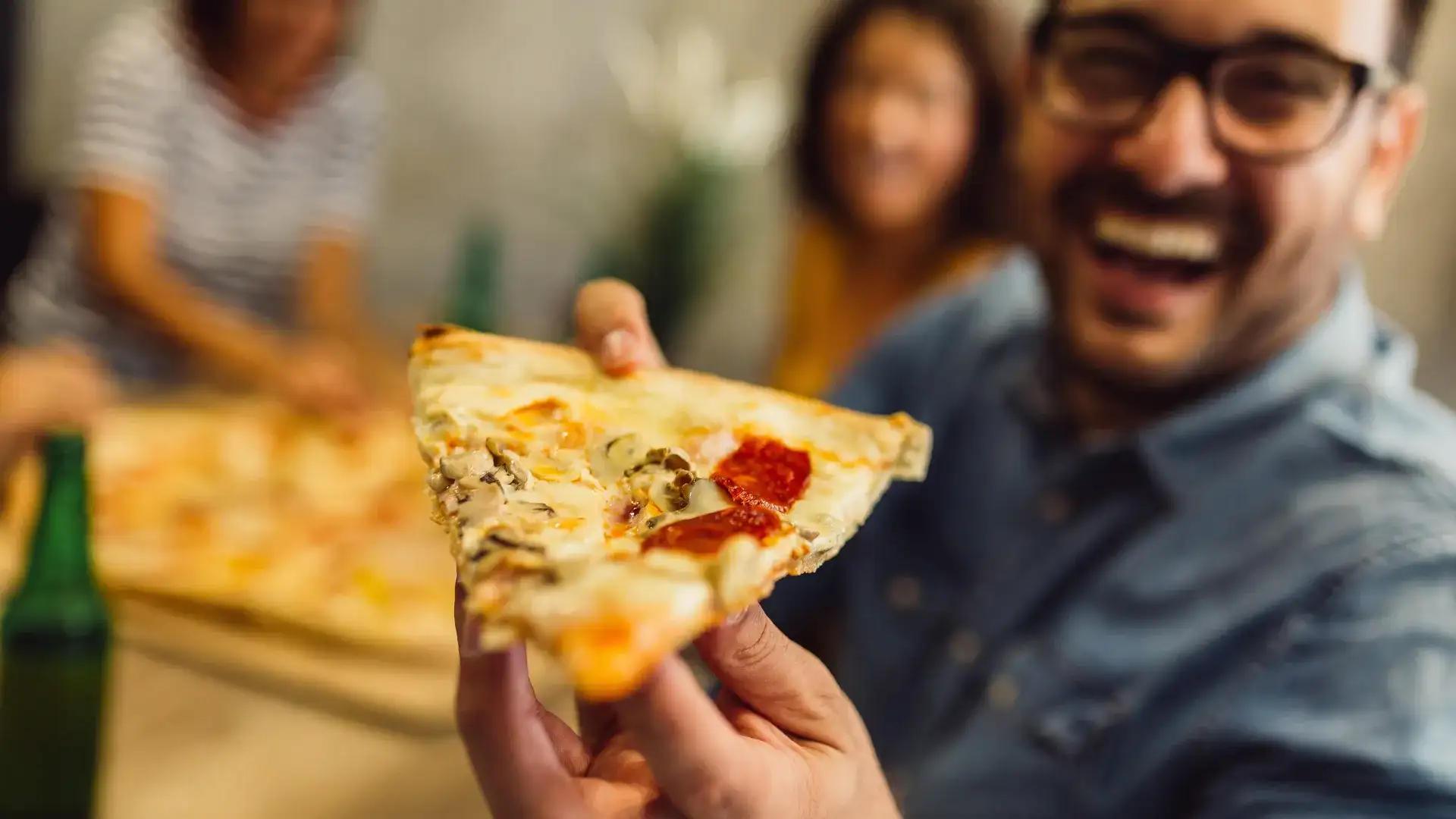 Man holding a slice of pizza.