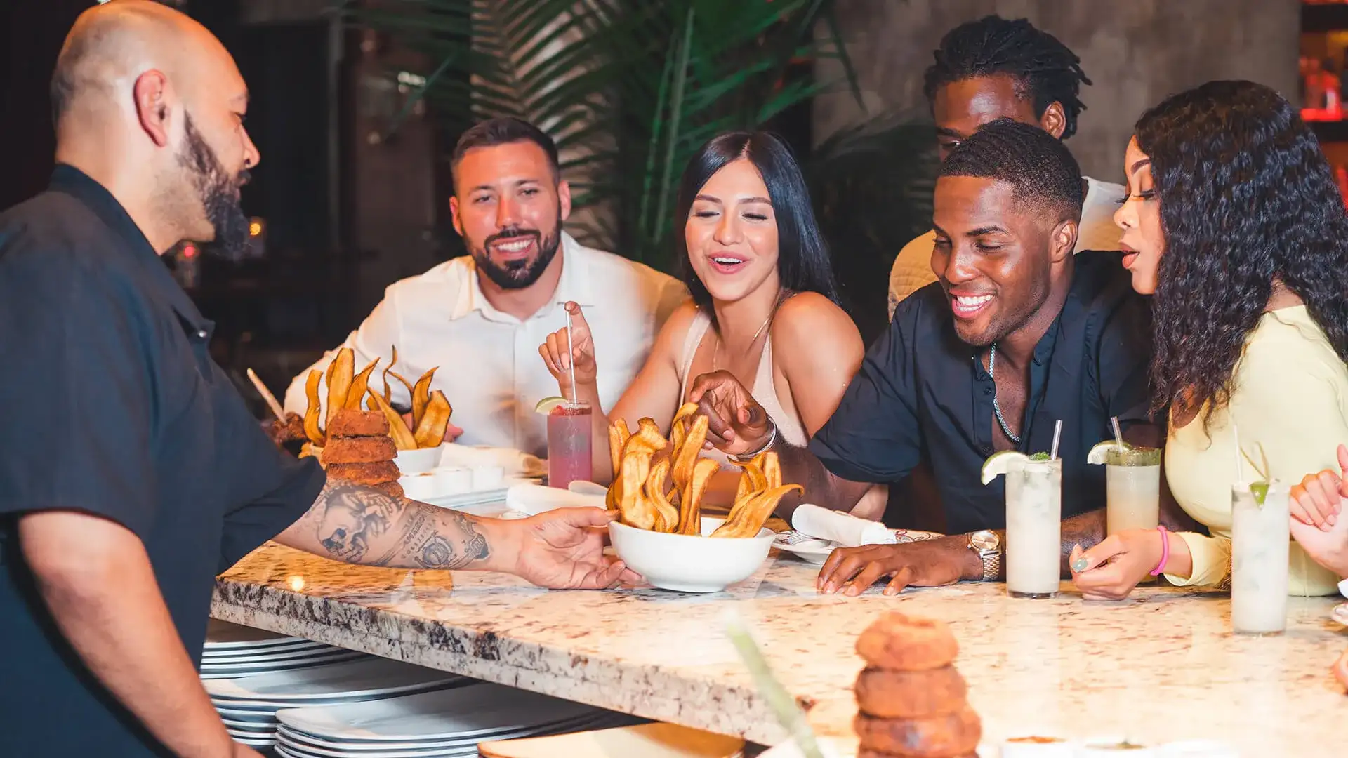 Group of people eating an appetizer at the bar.
