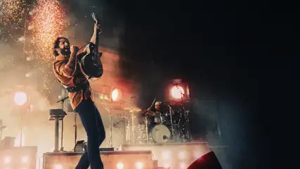 Thomas Rhett with an electric guitar on stage.