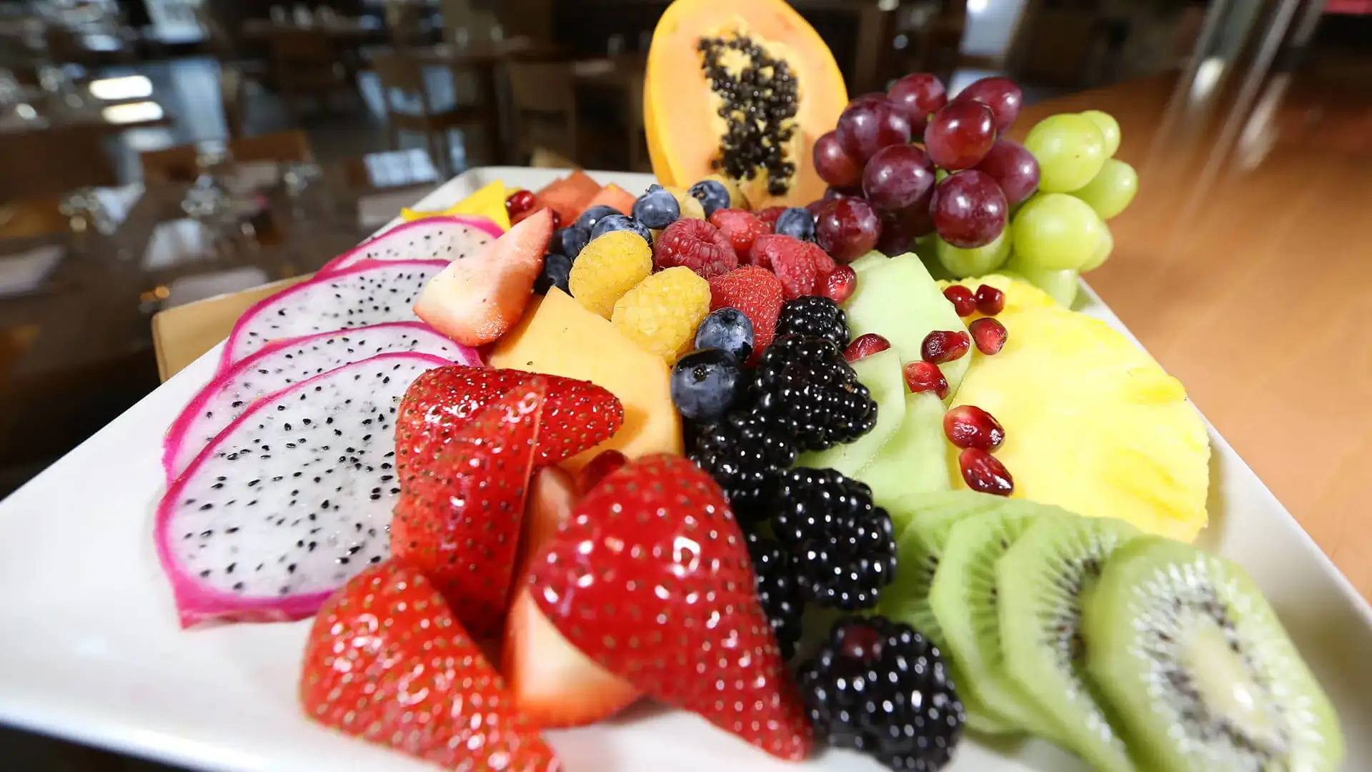Plate of strawberries, black berries, kiwi and other fresh fruit.