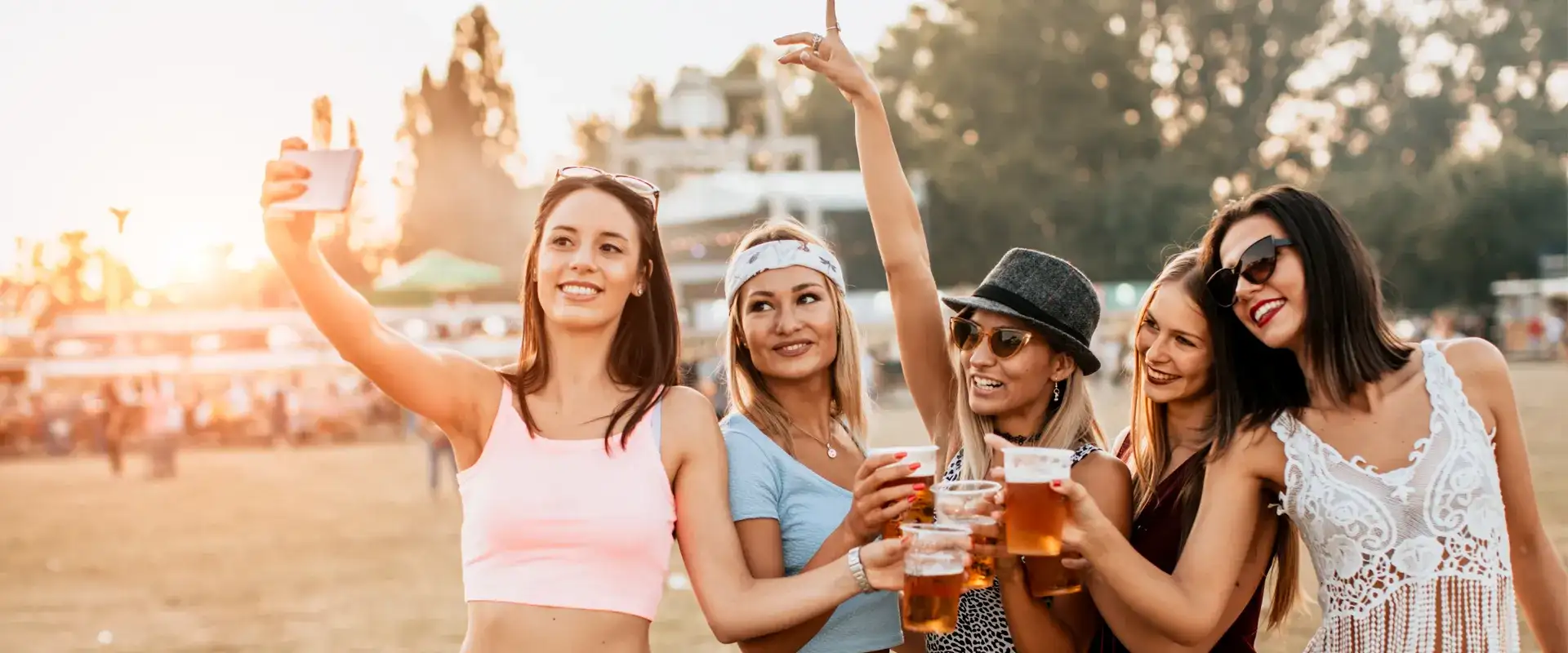 Group of women cheering with beer at an outdoor festival