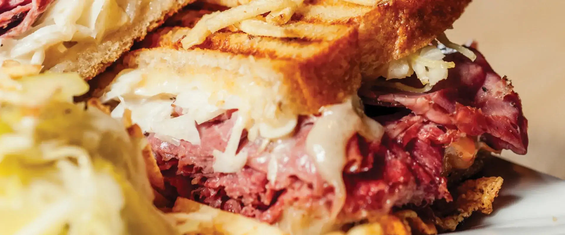 Toasted pastrami sandwich with grilled onions.