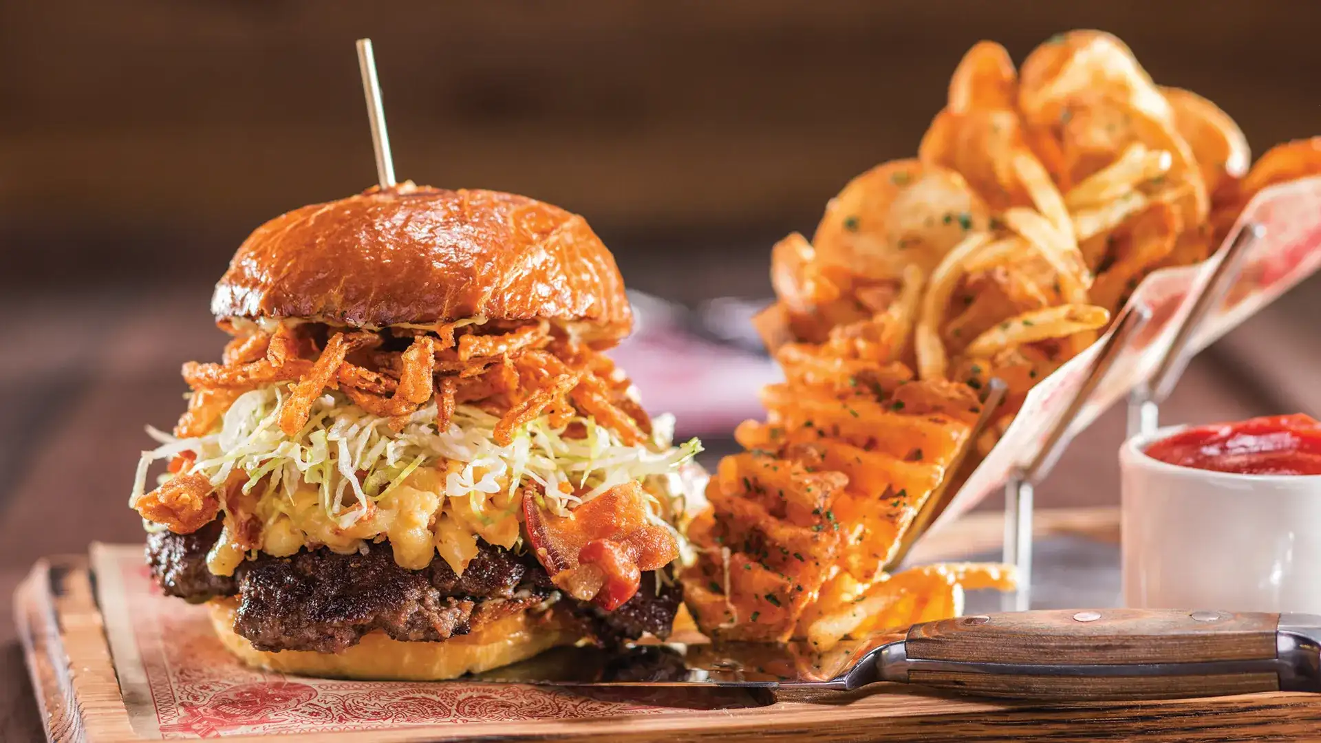 Huge burger with a side of curly cut fries from Guy Fieri's Vegas Kitchen and Bar