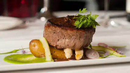Plated filet with bed of roasted vegetables.