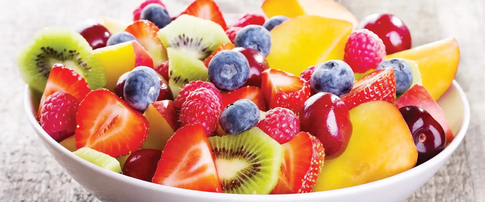 Fresh fruit bowl with strawberries, blueberries, kiwi and mango.