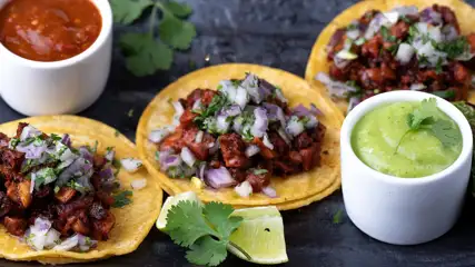 Tacos with a side of guacamole and salsa.
